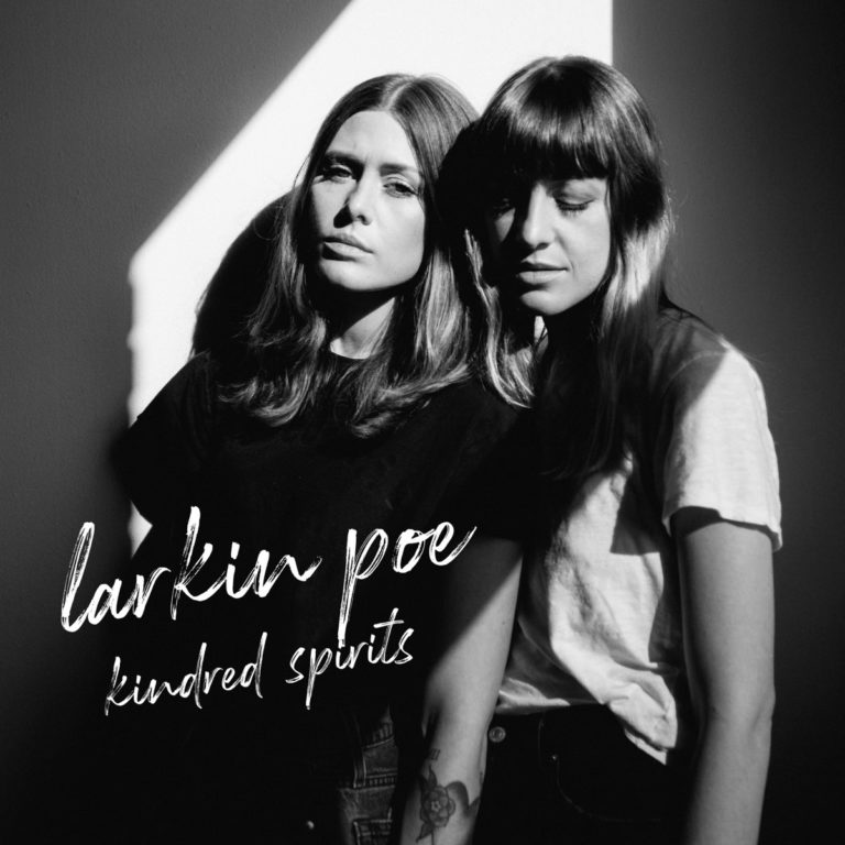Zwei Frauen stehen nebeneinander im Schatten, mit Schriftzug Larkin Poe Kindred Spirits.
