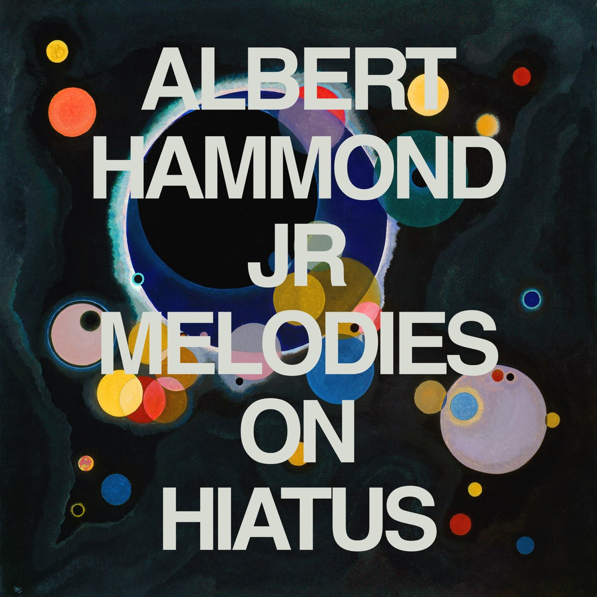 Buntes, abstraktes Artwork mit farbigen Kreisen auf schwarzem Hintergrund, Albumcover zu „Melodies on Hiatus“ von Albert Hammond Jr. mit großflächigem Text.