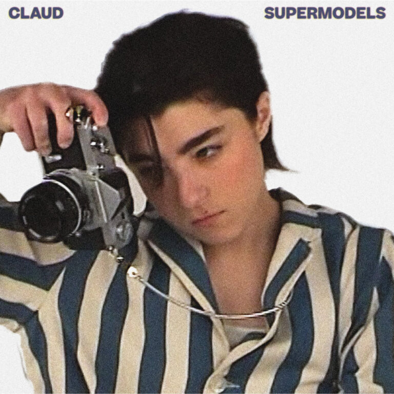 Albumcover von Claud „Supermodels“ zeigt Claud mit Strubbelhaaren und gestreiftem Pyjama, der gedankenverloren durch eine analoge Kamera blickt.