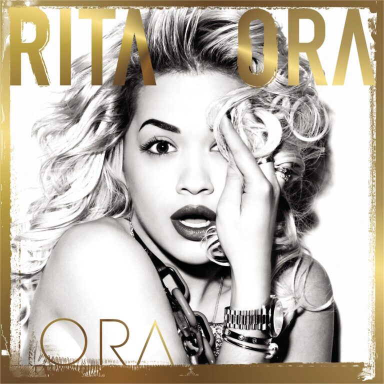 Schwarz-weißes Porträt von Rita Ora mit offenem Mund und Hand am Gesicht.