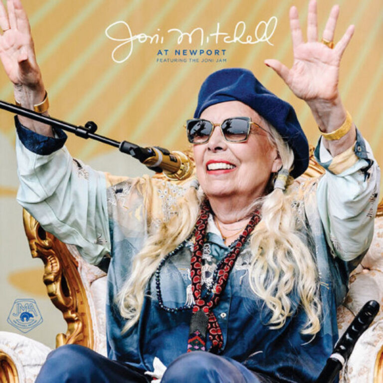 Joni Mitchell sitzt strahlend auf einem Thron beim Newport Folk Festival, trägt Sonnenbrille, Mütze und Seidenschal, beide Arme erhoben – Albumcover.