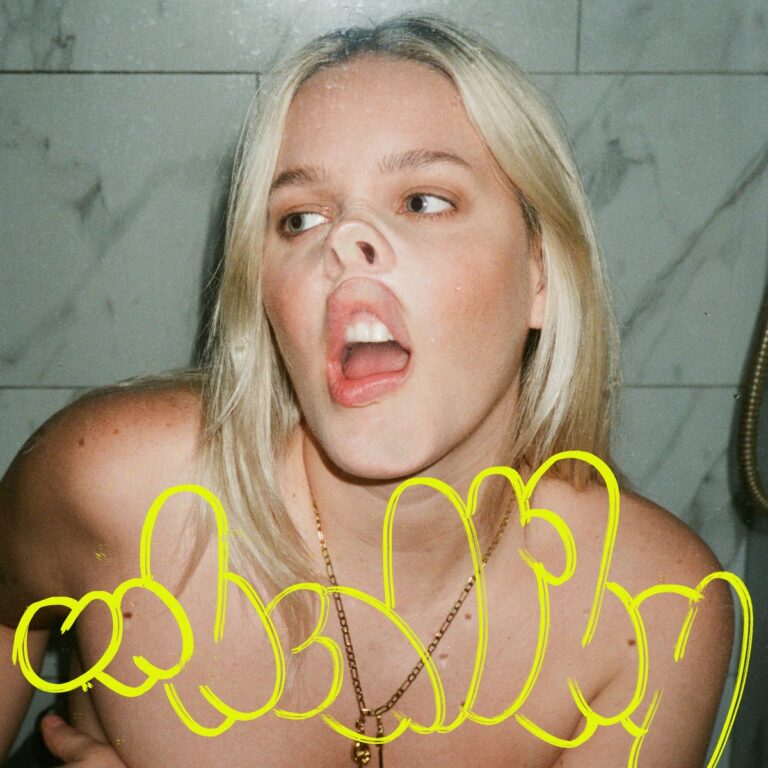 Provokantes Albumcover von Anne-Maries „Unhealthy“ zeigt die Sängerin mit verzerrtem Gesicht hinter Glas und gelbem Schriftzug im Graffiti-Stil.