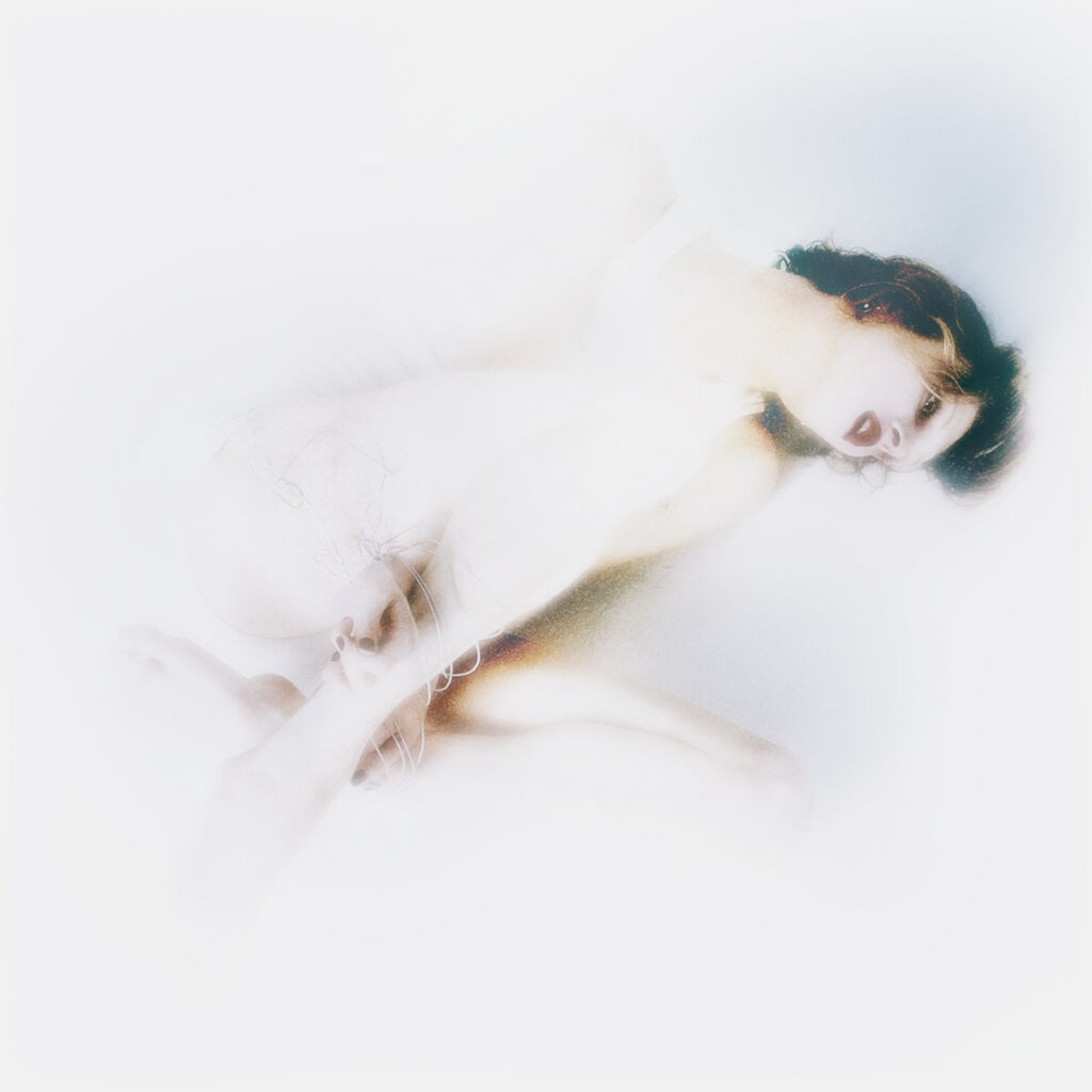 Ätherisches, überbelichtetes Albumcover von Lauren Auders „the infinite spine“, zeigt eine verschwommene Figur in Weiß in träumerischer Pose auf hellem Hintergrund.