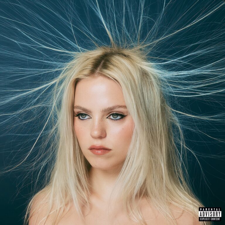 Albumcover von Snow Angel: Reneé Rapp mit ernstem Blick vor dunkelblauem Hintergrund, ihre hellblonden Haare strahlen elektrostatisch in alle Richtungen – ein visuelles Sinnbild für emotionale Aufladung.