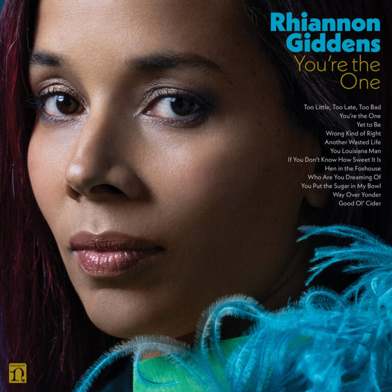 Nahaufnahme von Rhiannon Giddens mit intensivem Blick, schimmerndem Make-up und türkisfarbener Federboa; rechts die Songliste des Albums „You’re the One“.