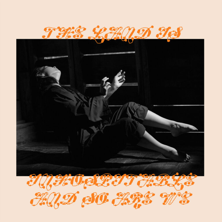 Schwarz-weißes Albumcover von Mitski – The Land Is Inhospitable and So Are We: Die Künstlerin sitzt dramatisch zurückgelehnt im Halbdunkel.
