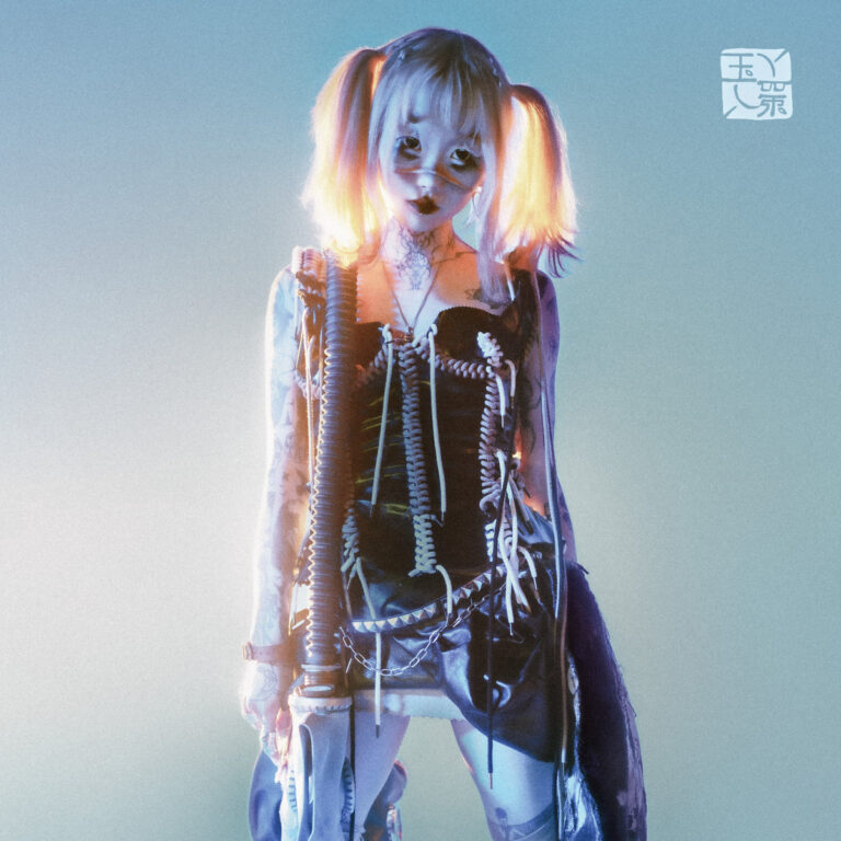yeule im futuristisch-zerfetzten Cyberpunk-Outfit mit leuchtenden Zöpfen vor pastellblauem Hintergrund – eine verletzliche Figur zwischen Mensch und Avatar