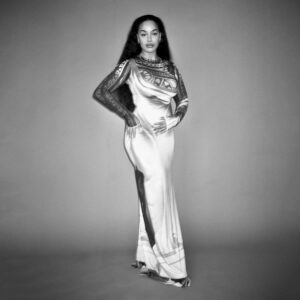 Albumcover zu „Falling or Flying“ von Jorja Smith – in einem langen, glänzenden Kleid steht sie selbstbewusst vor grauem Hintergrund, das Bild ist in Schwarz-Weiß gehalten.