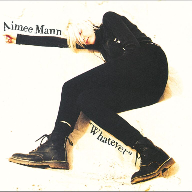 Frau mit blonden Haaren in schwarzer Kleidung lehnt an einer Wand, Albumtitel Whatever daneben.