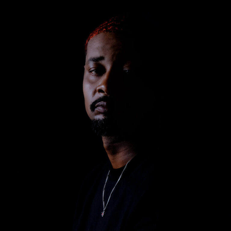 Dunkles Porträt von Danny Brown mit rotem Haaransatz, nur halb beleuchtet, als visuelles Statement zum introspektiven Album „Quaranta“.