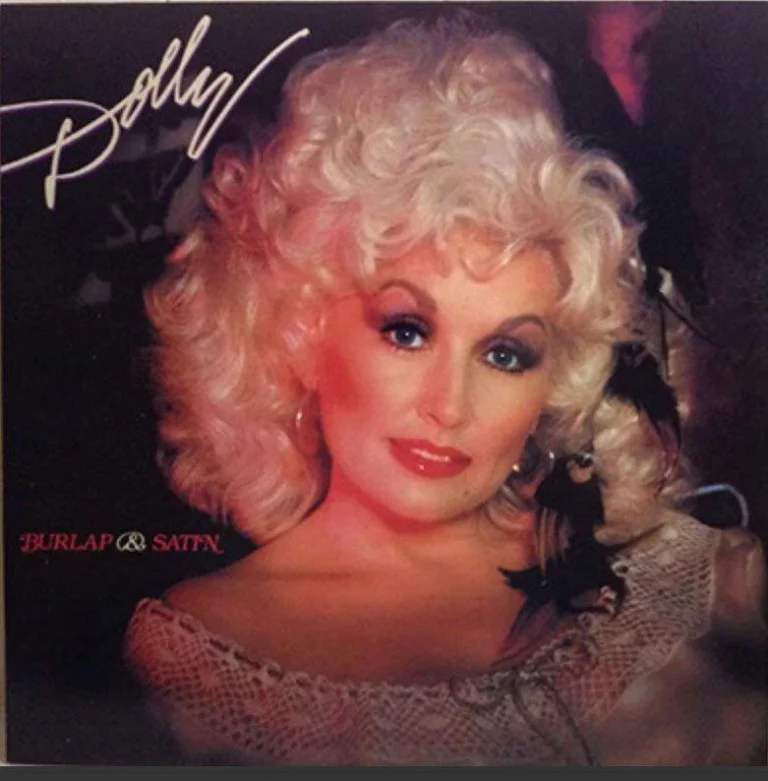 Porträt von Dolly Parton mit blondem Haar und Spitzenkleid auf dem Albumcover von Burlap & Satin.