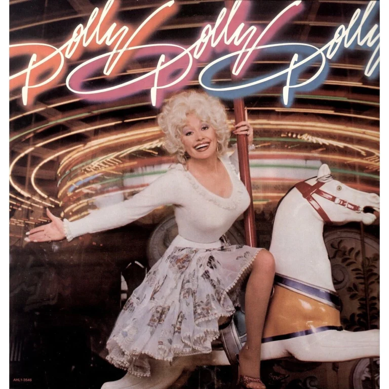 Dolly Parton sitzt auf einem Karussellpferd und lächelt fröhlich in einem weißen Kleid.