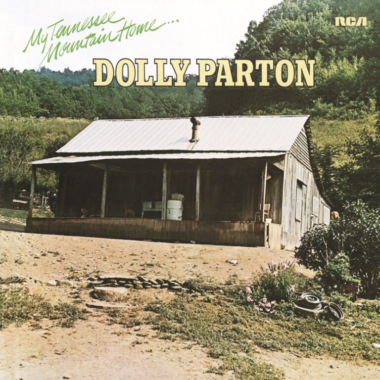 Albumcover von Dolly Parton mit einem Holzhaus in den Bergen und grünen Bäumen im Hintergrund.