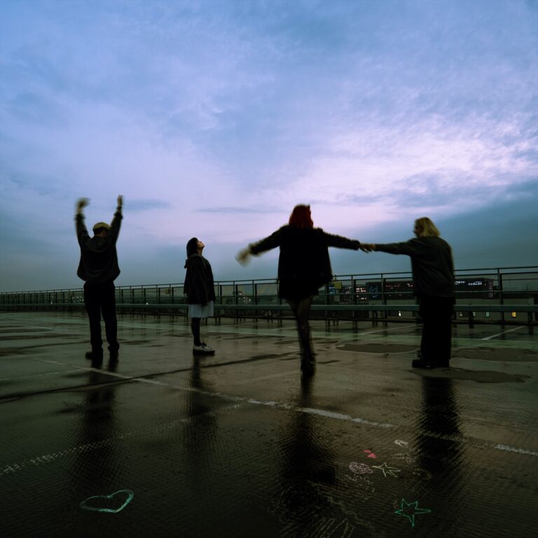 Albumcover von Crawlers – The Mess We Seem To Make: Vier Personen auf einem nassen Parkdeck im Gegenlicht, tanzend oder posierend unter einem blauen Abendhimmel.