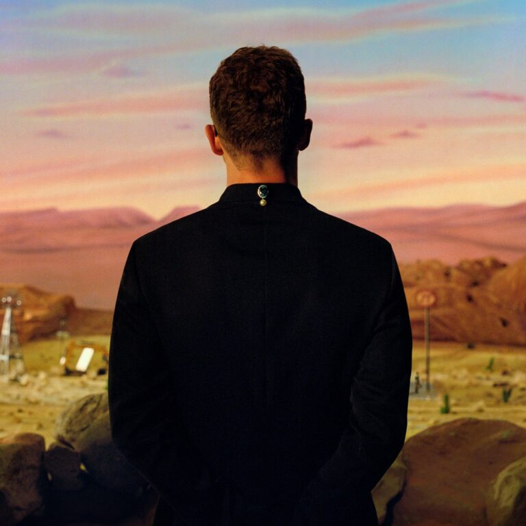 Albumcover von Justin Timberlakes „Everything I Thought It Was“ mit Rückenansicht vor surrealem Wüstenpanorama bei Sonnenuntergang.