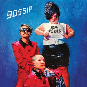 Gemäldeartiges Cover der Band Gossip – drei Mitglieder vor blauem Hintergrund, Beth Ditto im „Real Power“-Shirt, energiegeladene Pose.