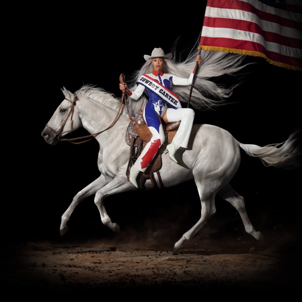 Beyoncé reitet auf einem weißen Pferd im Western-Outfit mit wehender Mähne und USA-Flagge – das ikonische Cover zu Cowboy Carter.