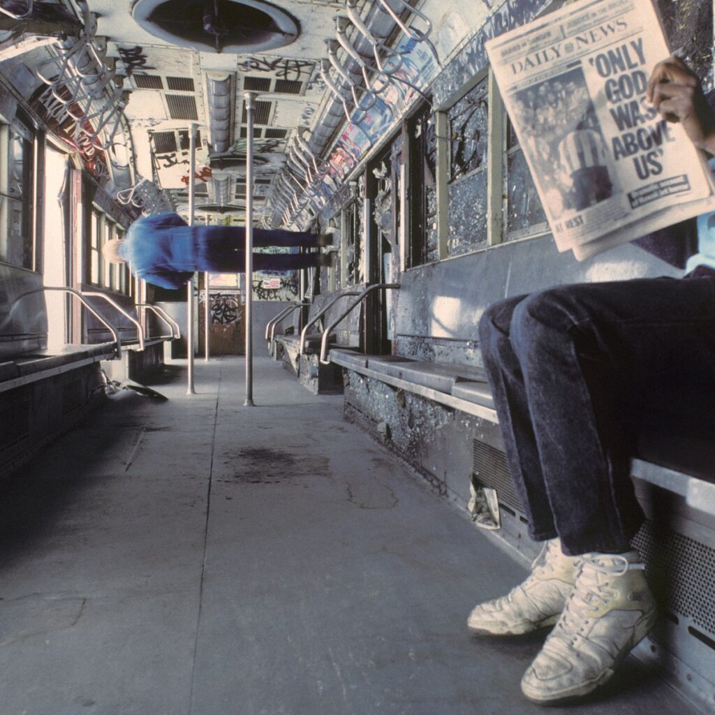 Albumcover von Vampire Weekend – Only God Was Above Us zeigt einen verfallenen, graffitiübersäten U-Bahn-Waggon mit einer Zeitungsschlagzeile als zentrales Motiv.