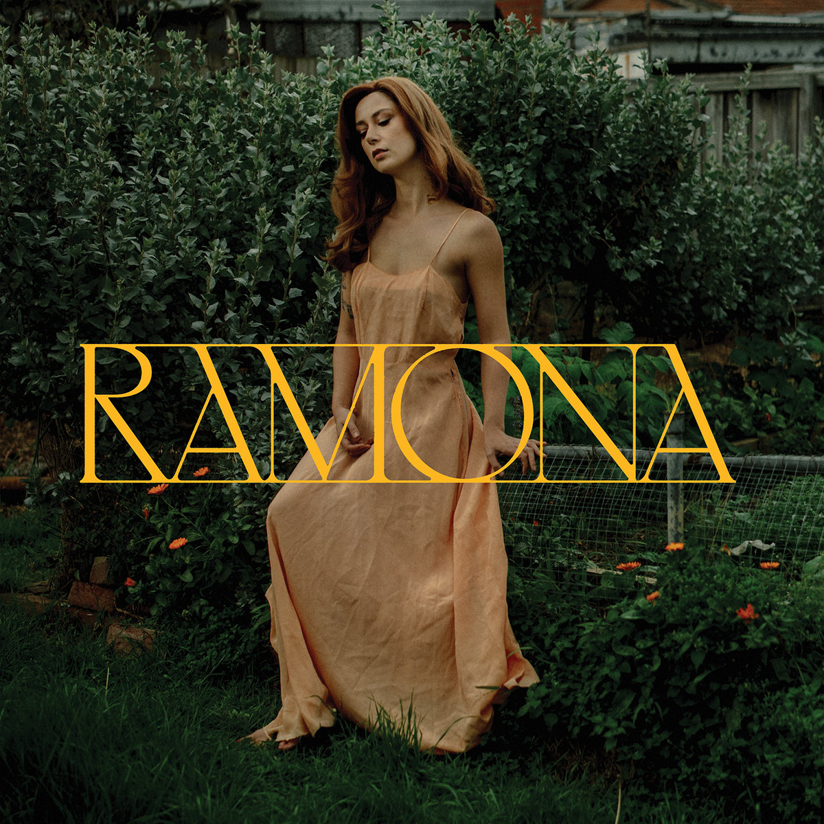 Grace Cummings in einem fließenden Kleid im Garten – verträumt, verwunschen, eine moderne „Ramona“ im Dialog mit der Natur.