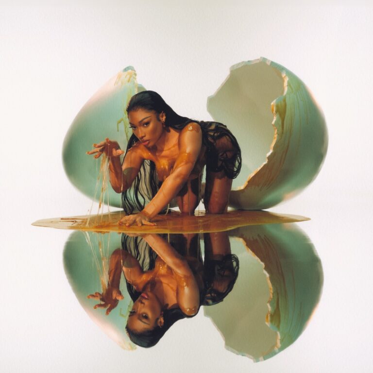 Megan Thee Stallion kriecht nackt und mit Eigelb bedeckt aus einer zerbrochenen Eierschale, ihr Spiegelbild im flüssigen Untergrund – surrealistisches Cover des Albums MEGAN.