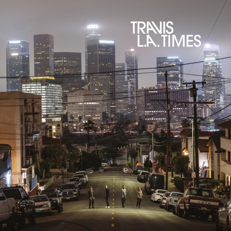 Coverfoto des Travis-Albums „L.A. Times“ mit Bandmitgliedern auf nächtlicher Straße vor der Skyline von Los Angeles im Dunst der Großstadtlichter.
