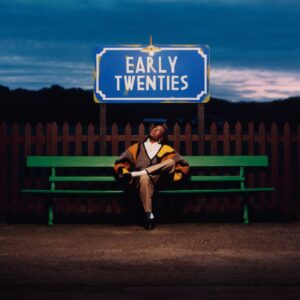 Das Cover von early twenties zeigt Cat Burns abends auf einer grünen Bank unter einem beleuchteten Schild mit dem Titel des Albums – eine Momentaufnahme zwischen Stillstand und Aufbruch.