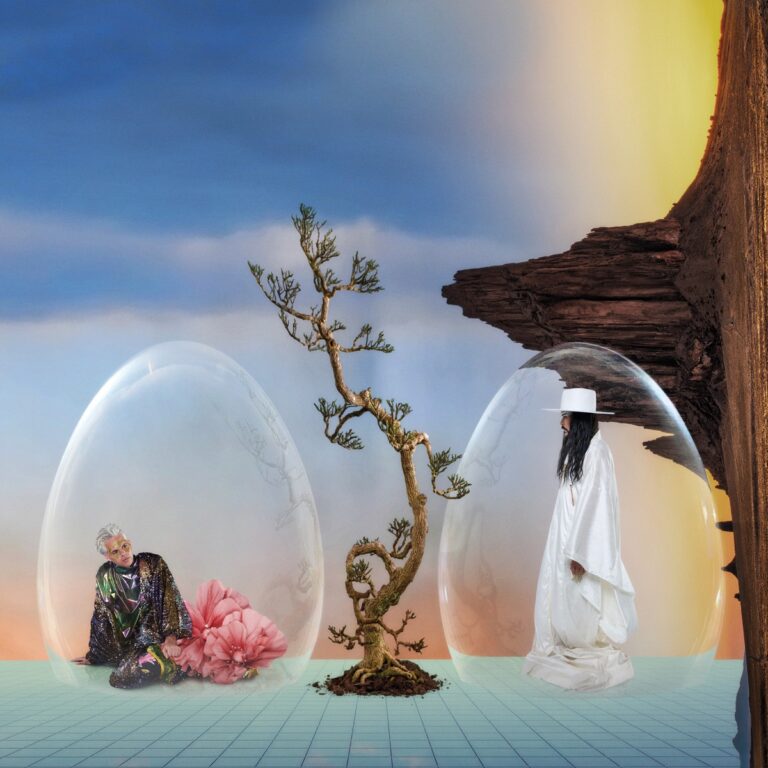 Surreales Cover zu „Ask That God“ von Empire of the Sun mit zwei Figuren in gläsernen Kuppeln, einem verdrehten Baum und fantastischer Felslandschaft.