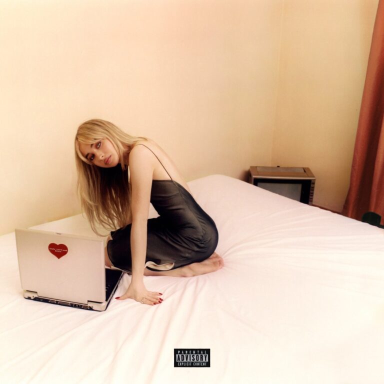 Sabrina Carpenter sitzt im seidenen Slipdress auf einem ungemachten Bett, vor einem weißen Laptop mit rotem Herz-Sticker – der Raum wirkt nüchtern, intim und retro. Ihr Blick ist nachdenklich, verletzlich – das Cover strahlt ruhige Verletzlichkeit und emotionale Selbstentblößung aus.