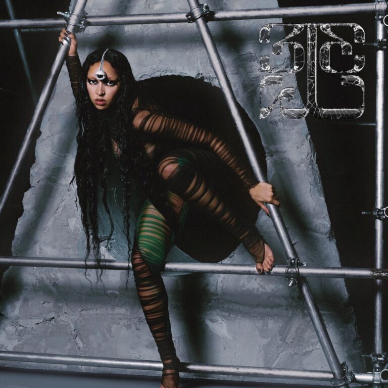 Tinashe posiert kraftvoll in einem futuristischen Gerüst, umgeben von kühlem Beton – zwischen Performance, Selbsterlösung und digitalem Totem.