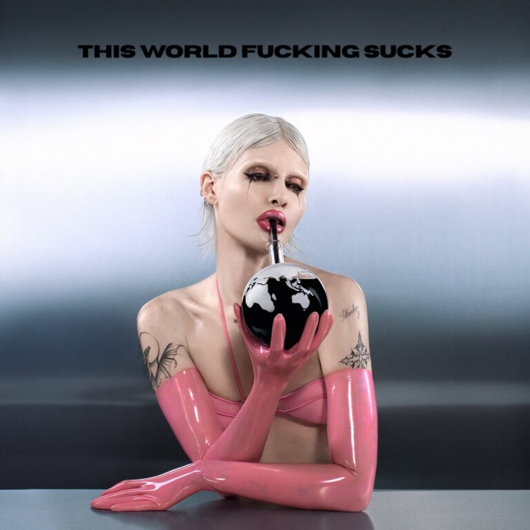 Albumcover von This World Fucking Sucks zeigt Cassyette in Latexhandschuhen und pinkem Top, wie sie durch einen Strohhalm aus einem Erdball trinkt – ein provokantes, postapokalyptisches Symbolbild mit Glam-Attitüde.