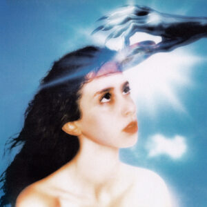 Cover des Albums Imaginal Disk von Magdalena Bay: Eine junge Frau blickt himmelwärts, während eine silbrig-robotische Hand ihre Stirn berührt – eine surreale, retrofuturistische Vision zwischen Traum und Technologie.