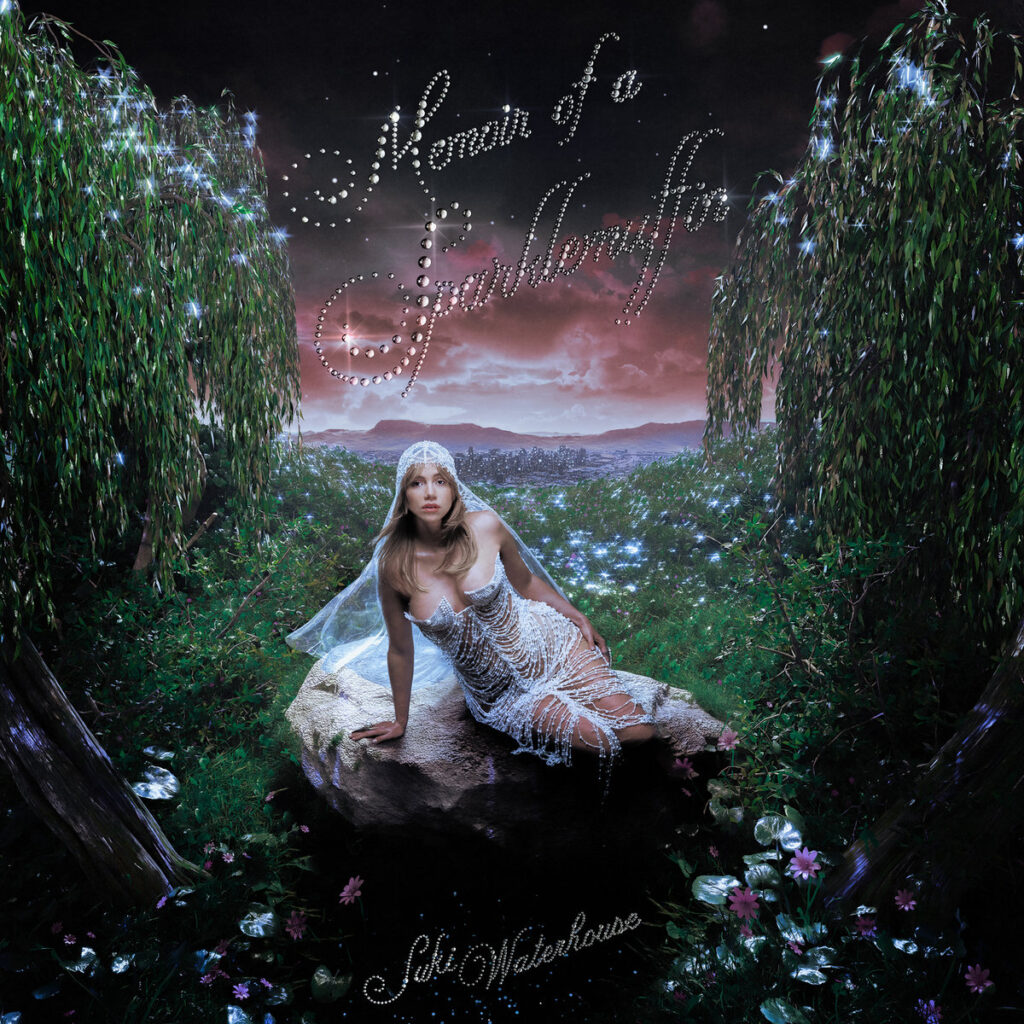 Albumcover zu Memoir of a Sparklemuffin zeigt Suki Waterhouse in einem funkelnden Kleid, auf einem Felsen thronend, vor einer leuchtenden, märchenhaften Landschaft.
