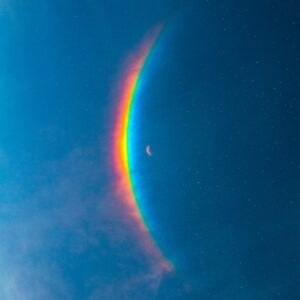 Cover des Coldplay-Albums „Moon Music“: eine Mondsichel schwebt unter einem leuchtenden Regenbogenbogen inmitten eines tiefblauen Sternenhimmels.