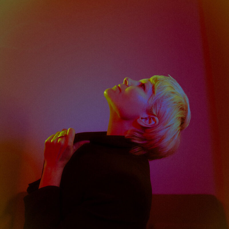 Porträt von Liela Moss im farbig changierenden Licht – mit geschlossenem Blick und nach hinten geneigtem Kopf – Artwork zum Album „Transparent Eyeball“.