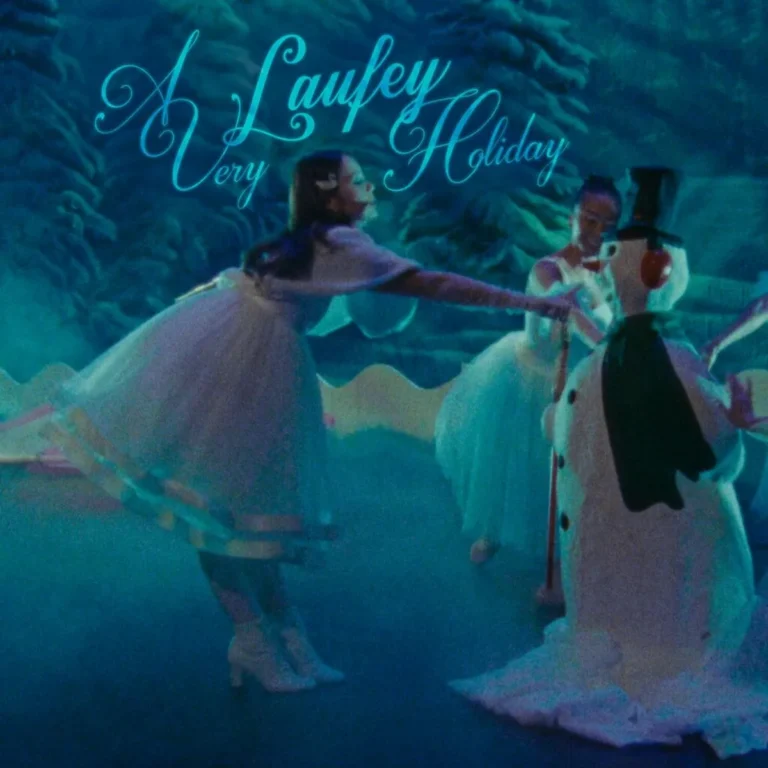 Albumcover „A Very Laufey Holiday“: Winterliche Szene in blauem Licht, Tänzerinnen im weißen Tüllkleid tanzen mit einem Schneemann, im Hintergrund verschneite Bäume.