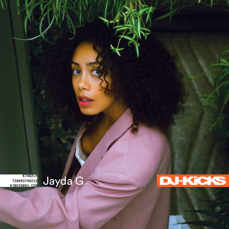 Jayda G steht in einem rosa Blazer unter herabhängenden grünen Pflanzen und blickt direkt in die Kamera. Das Cover ist modern, natürlich und intim gestaltet. Unten rechts steht DJ-Kicks, links ihr Name und ein Barcode-Label.