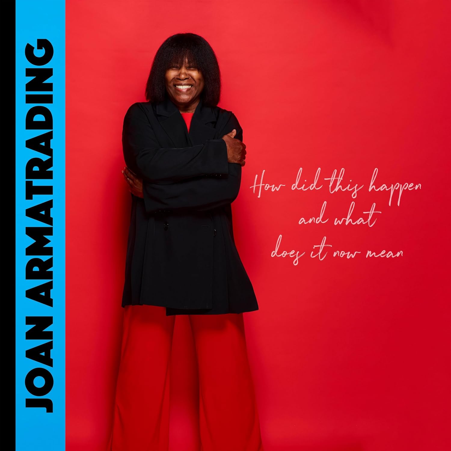 Joan Armatrading steht lachend vor rotem Hintergrund, trägt schwarzes Oberteil und rote Hose; links der Albumtitel, rechts der Schriftzug „How did this happen and what does it now mean“.