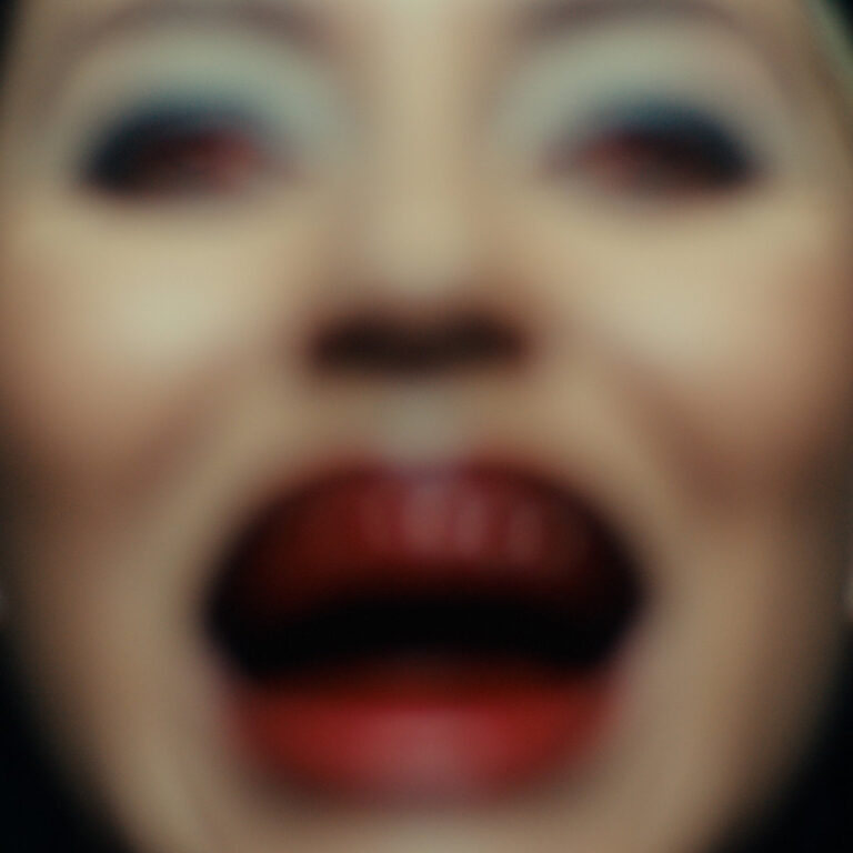 Unscharfes, expressives Nahaufnahme-Cover der Acid Latino EP mit starkem Fokus auf rot geschminktem Mund und ausdrucksvollem Make-up – Artwork von Paula Tape.
