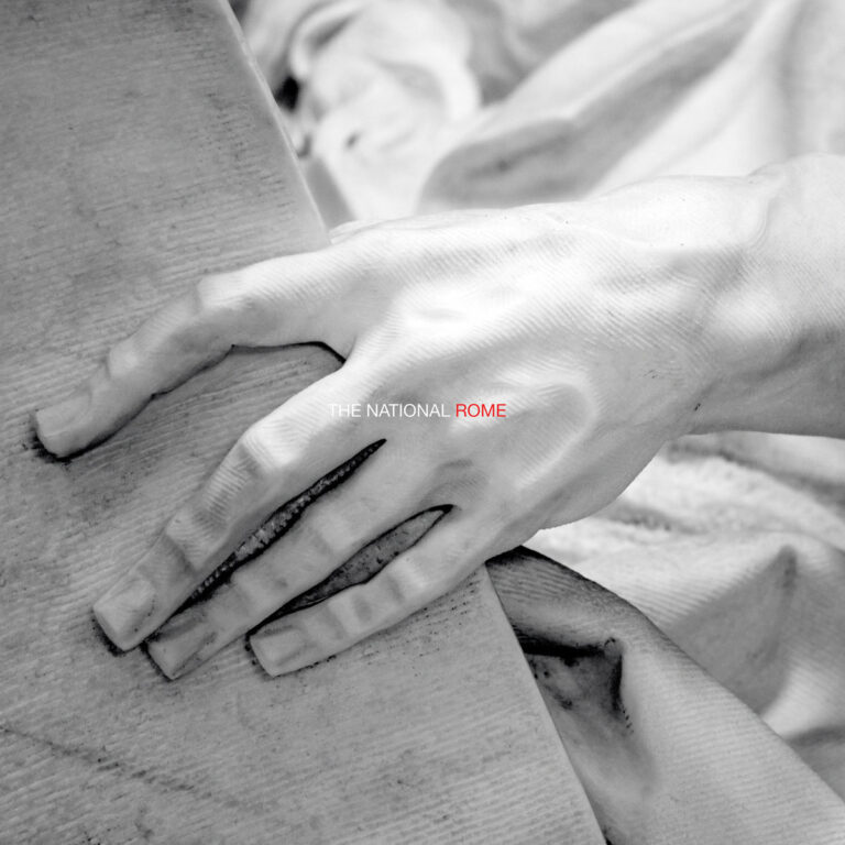 Detailaufnahme einer klassisch anmutenden Skulpturenhand, die eine raue Fläche umfasst – Artwork des Livealbums Rome von The National.
