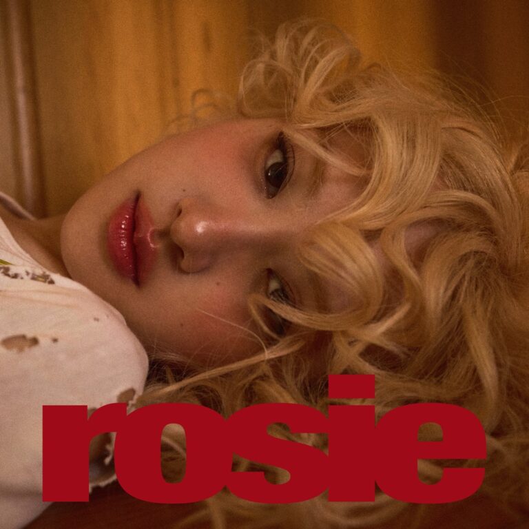 Nahaufnahme von ROSÉ mit blond gelocktem Haar, liegend und verträumt blickend – Cover des Soloalbums rosie, mit rotem Schriftzug.