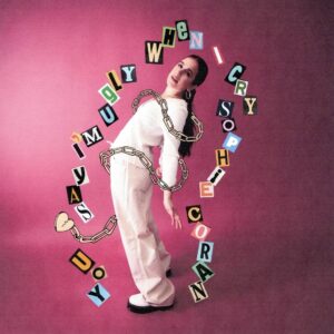 Cover der Single „you say i'm ugly when i cry“ von Sophie Coran mit pinkem Hintergrund, der Künstlerin in weißem Outfit und aus Buchstaben gebildetem Songtitel.