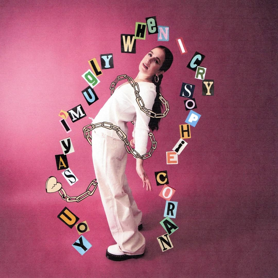 Cover der Single „you say i'm ugly when i cry“ von Sophie Coran mit pinkem Hintergrund, der Künstlerin in weißem Outfit und aus Buchstaben gebildetem Songtitel.