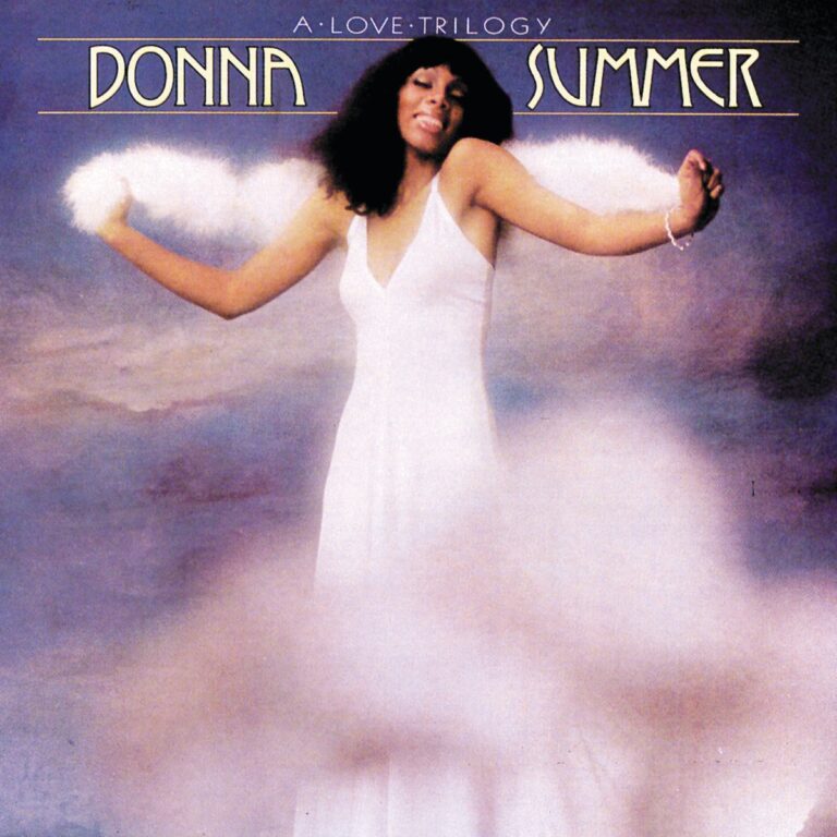 Donna Summer in einem weißen Kleid, umgeben von Wolken, lächelt und breitet die Arme aus.