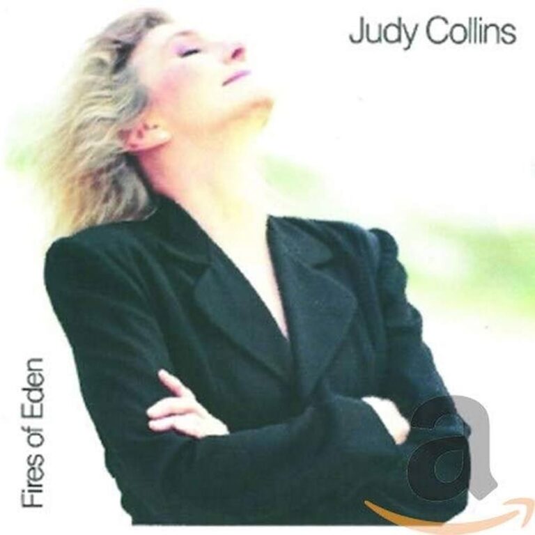Judy Collins in einem schwarzen Blazer mit geschlossenen Augen, Kopf leicht nach oben geneigt, vor hellem Hintergrund.