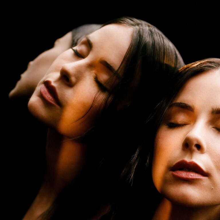 Albumcover mit künstlerischer Fotografie: Mehrfachbelichtung einer Frau mit geschlossenen Augen, deren Gesicht in sanftem Licht mehrfach gespiegelt erscheint, vor schwarzem Hintergrund.