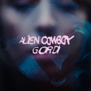 Das Cover zeigt verschwommene Gesichtszüge hinter einem Glas, auf dem mit rosa Schrift „Alien Cowboy Gordi“ geschrieben steht – daneben ein gemaltes Herz. Eine stimmungsvolle Darstellung von Distanz, Sehnsucht und emotionaler Tiefe.
