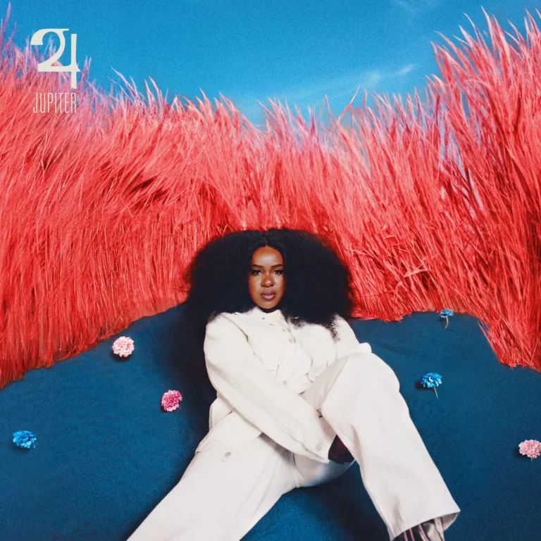 Das Albumcover zu Jupiter zeigt NAO in weißem Outfit vor surrealem, leuchtend rotem Gras und tiefblauem Boden – ein visuelles Symbol für Erneuerung, Stärke und kreative Freiheit.