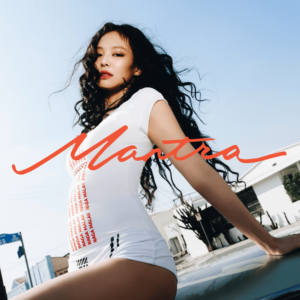 Cover von JENNIEs Solo-Single „Mantra“: Die Künstlerin lehnt in weißem Body vor urbaner Kulisse, mit rotem Schriftzug „Mantra“ – stark, sinnlich, stilbewusst.