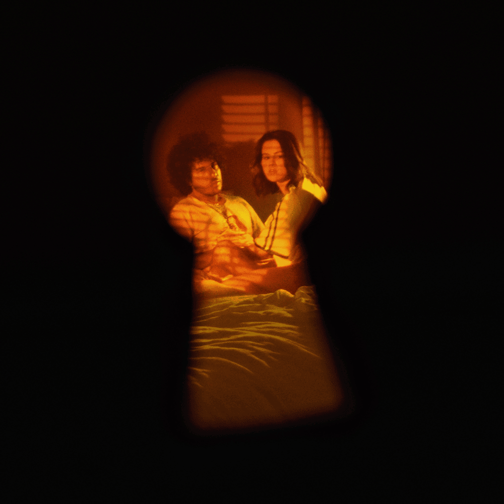 Durch ein Schlüsselloch fotografierte Szene: Selena Gomez und Gracie Abrams auf einem Bett in warmer Lichtstimmung – intimes Artwork zur gemeinsamen Single.