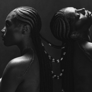 Schwarz-weiß Porträt von zwei Frauen mit kunstvoll geflochtenen Zöpfen, die Rücken an Rücken stehen – stilisiertes Artwork zu Doechii's Single „Anxiety“.